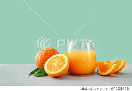 Close up of orange juice in a glass with oranges Close up of orange juice in a glass with oranges 64288626