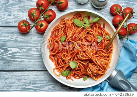 Delicious pasta with tomato sauce on blue 64288639