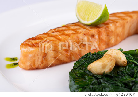 Grilled trout steak, served with lime, garlic sauce and asparagus 64289407