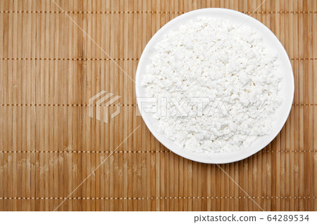 bowl with cottage cheese on the table, top view 64289534