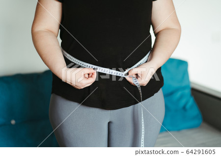 overweight, diet. fat woman with measuring tape overweight, diet. fat woman with measuring tape 64291605