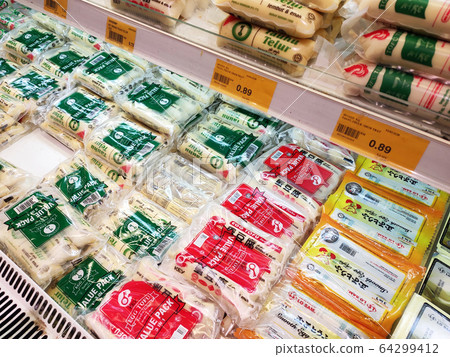 Tofu also known as bean curd displayed for sale on the rack inside the supermarket. It is a food prepared by coagulating soy milk and then pressing the resulting curds into solid white blocks or other 64299412