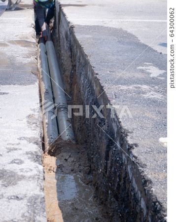 workers are installing concrete drains on the side 64300062