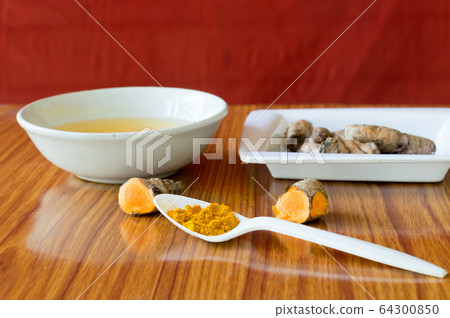 Table spoon of Pure Turmeric Haldi Powder. Haldi turmeric milk recipe.  64300850