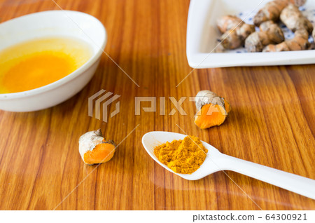 A table spoon of Pure Turmeric Haldi Spices Powder. Turmeric with Water.  64300921