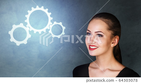 Business woman looks on working cogwheels. Business woman looks on working cogwheels. 64303078