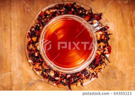 Cup of hot tea with rock sugar, dry tea leaves served in thermo glass tea cup 64303121