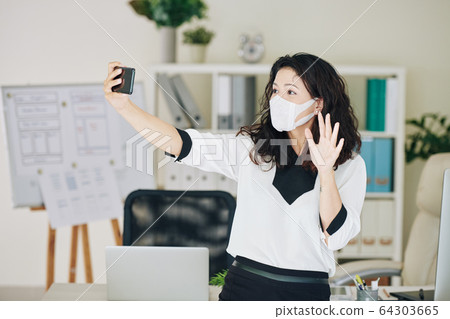 Businesswoman in medical mask making video 64303665