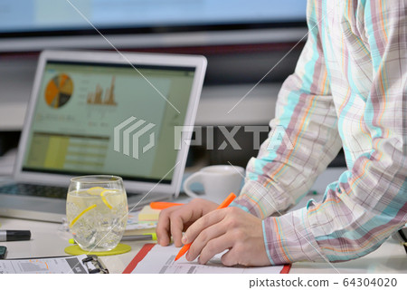 Business adviser analyzing financial figures close-up 64304020