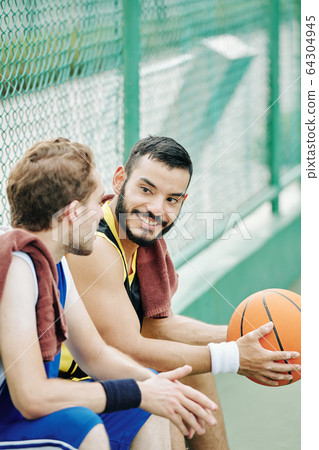 Basketball player looking at talking friend Basketball player looking at talking friend 64304945