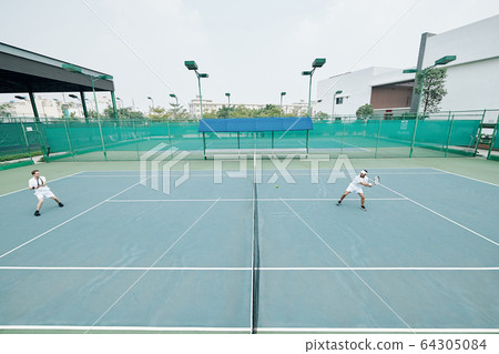 Friends playing game of tennis 64305084