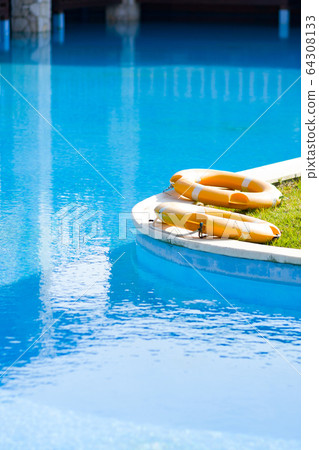 Lifebuoys by outdoor pool at luxury hotel. Lifebuoys by outdoor pool at luxury hotel. 64308133
