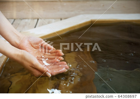 Female hands scooping hot spring water Female hands scooping hot spring water 64308697