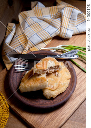 Clay plate of fried meat pies with cutlery and Clay plate of fried meat pies with cutlery and 64309198