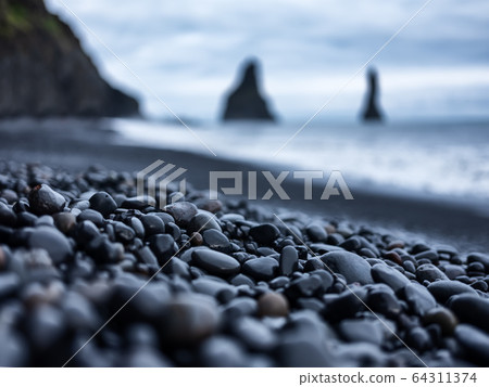 Black pebbles as a background in the Iceland sea shore. Abstract composition. 64311374