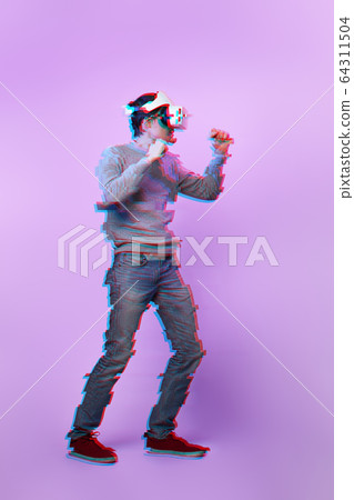 Man with virtual reality headset is playing game and fighting. Image with glitch effect. 64311504