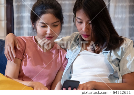 Happy asian lesbain couple watching video on Happy asian lesbain couple watching video on 64312631