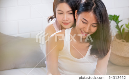 Asian lesbian couple hug each other on bed in Asian lesbian couple hug each other on bed in 64312632