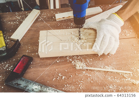 Carpenter working on wood craft at workshop 64313156