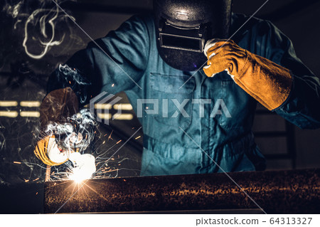 Metal welder working with arc welding machine. Metal welder working with arc welding machine. 64313327