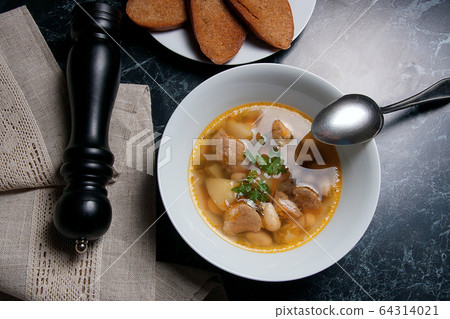 Bean soup in white plate with metal spoon, several 64314021