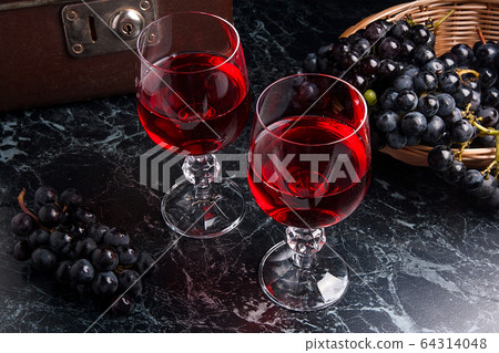 Glass of red wine on dark marble background. 64314048