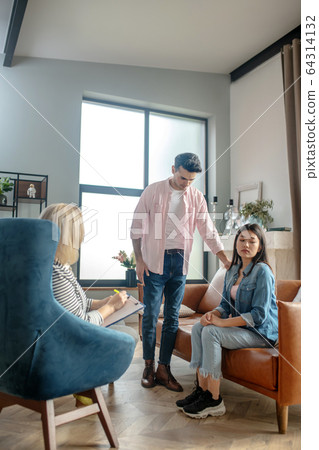 Dark-haired tall man standing next to his girlfriend Dark-haired tall man standing next to his girlfriend 64314132