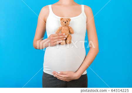 Cropped image of teddy bear in hand against Cropped image of teddy bear in hand against 64314225