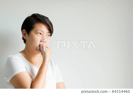 A side face of a woman feeling nervous anxious; listless and expression by biting nail of the thumb. A side face of a woman feeling nervous anxious; listless and expression by biting nail of the thumb. 64314460