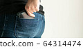 Close-up of the side of a person use left hand to bring out a wallet from the back pocket of jeans. 64314474