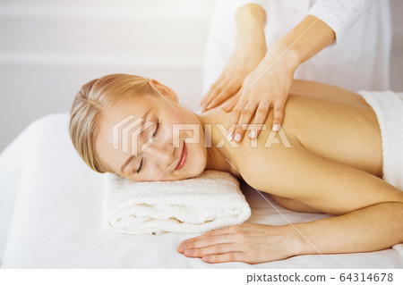 Caucasian woman getting a back massage in the spa salon Stock