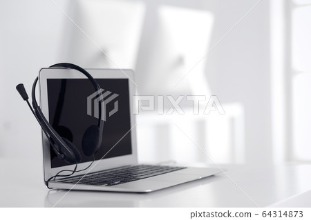 Call center and communication support, customer service help desk. VOIP headset on laptop computer Call center and communication support, customer service help desk. VOIP headset on laptop computer 64314873