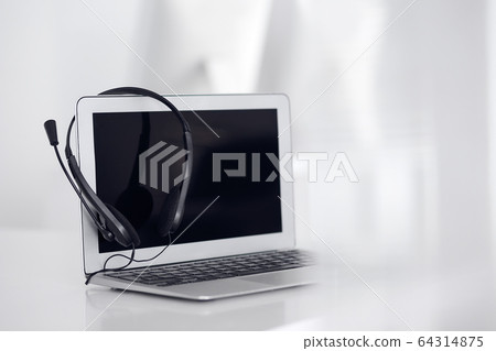 Call center and communication support, customer service help desk. VOIP headset on laptop computer Call center and communication support, customer service help desk. VOIP headset on laptop computer 64314875