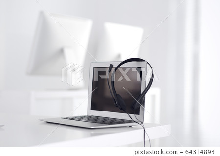 Call center and communication support, customer service help desk. VOIP headset on laptop computer Call center and communication support, customer service help desk. VOIP headset on laptop computer 64314893