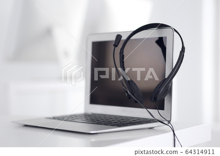 Call center and communication support, customer service help desk. VOIP headset on laptop computer Call center and communication support, customer service help desk. VOIP headset on laptop computer 64314911
