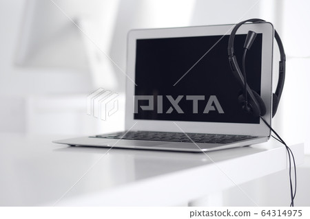 Call center and communication support, customer service help desk. VOIP headset on laptop computer Call center and communication support, customer service help desk. VOIP headset on laptop computer 64314975