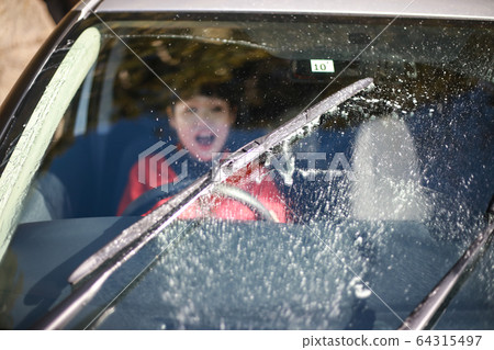 Surprised woman with washer fluid coming out 64315497