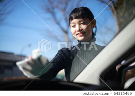 Woman wiping the windshield 64315499
