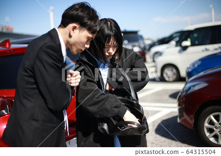 Couple looking for car key in parking lot Couple looking for car key in parking lot 64315504