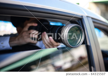 A man taking a picture from inside the car 64315507