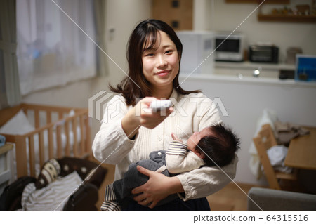 Mother turning on air conditioner 64315516