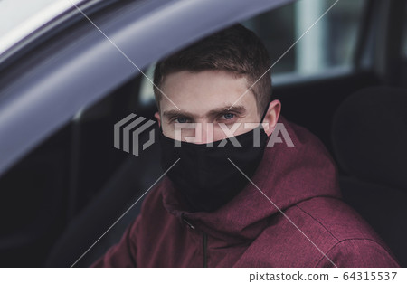a man driving a car in black protective mask a man driving a car in black protective mask 64315537