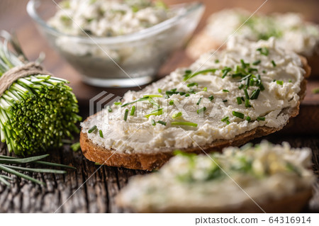 Chive cream cheese spread on a bread slice next to Chive cream cheese spread on a bread slice next to 64316914