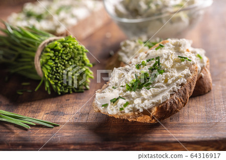 Chive cream cheese spread on a bread slice next to 64316917