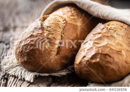 Close up of crunchy loafs of bread covered in a Close up of crunchy loafs of bread covered in a 64316936