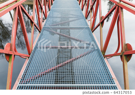 Modern metal bridge view with red handrails Modern metal bridge view with red handrails 64317053