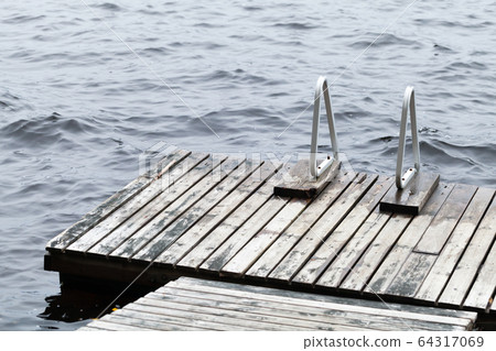 Old wooden pier with metal rails for swimming Old wooden pier with metal rails for swimming 64317069