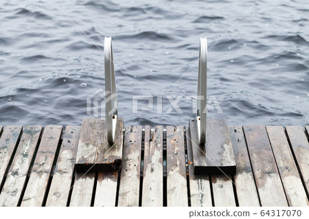 Wooden pier edge with metal rails for swimming 64317070