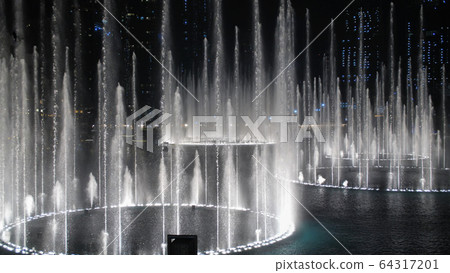 Dancing fountains in Dubai in the evening. Dancing fountains in Dubai in the evening. 64317201