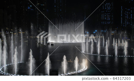 Dancing fountains in Dubai in the evening. Dancing fountains in Dubai in the evening. 64317203